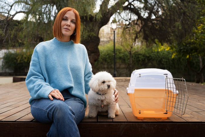 a dog sitting next to a crate with his mom